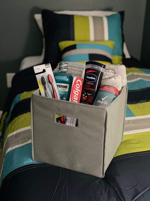 Welcome hygiene kit with toiletries placed on a made bed in a furnished room