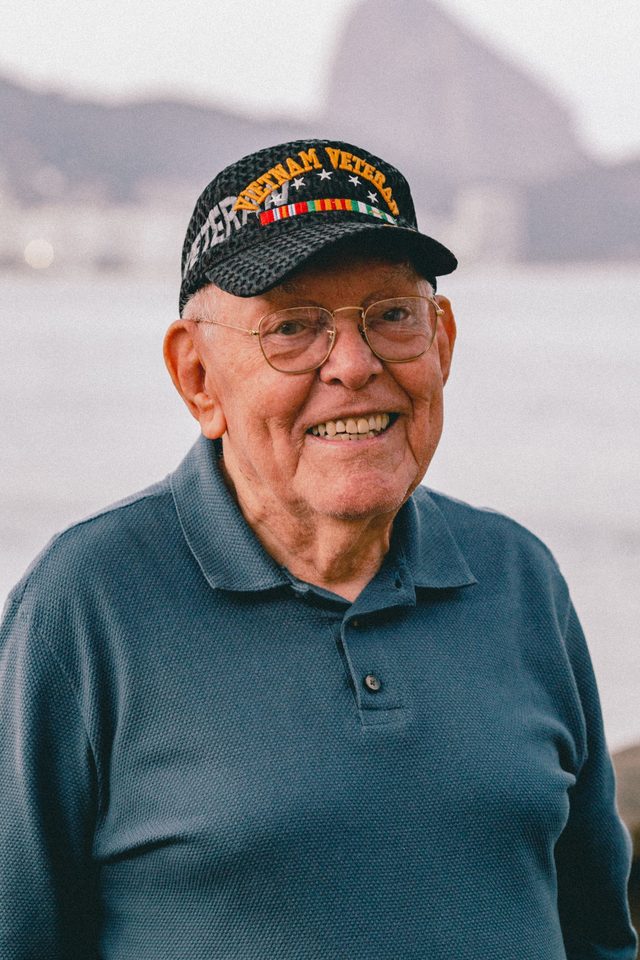 A smiling older man wearing a Vietnam Veteran cap